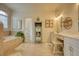 Bright bathroom featuring a soaking tub, linen cabinet, and a vanity with decorative accents at 3818 Bay Forest Way, Loganville, GA 30052