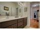 Bathroom featuring a double vanity with wood cabinets and a door that leads to a bedroom and closet at 3818 Bay Forest Way, Loganville, GA 30052