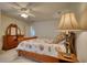 Bedroom featuring a wooden bedframe, side table, ceiling fan, and decorative lamps on both sides at 3818 Bay Forest Way, Loganville, GA 30052