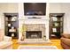 Close-up of the stone fireplace, flanked by built-in shelving and hardwood floors at 3818 Bay Forest Way, Loganville, GA 30052