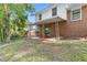 A lovely backyard patio featuring a brick house with a covered seating area and a lush green lawn at 46 Hawkins Store Nw Rd, Kennesaw, GA 30144