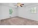 Bedroom featuring neutral carpet and a ceiling fan, brightened by two natural light filled windows with greenery views at 46 Hawkins Store Nw Rd, Kennesaw, GA 30144