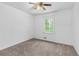 Bright bedroom featuring neutral carpet, a ceiling fan, and a window with a view of surrounding greenery at 46 Hawkins Store Nw Rd, Kennesaw, GA 30144