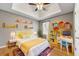 Bright bedroom featuring a ceiling fan, and colorful shelves for storage at 6687 Hill Creek Cv, Lithonia, GA 30058