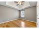 Spacious bedroom with a ceiling fan, tray ceiling, and natural light at 6687 Hill Creek Cv, Lithonia, GA 30058