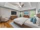 Serene primary bedroom boasts a tray ceiling, ceiling fan, and neutral color palette at 6687 Hill Creek Cv, Lithonia, GA 30058