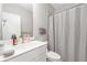 Bright bathroom featuring a white sink vanity, toilet, and shower with a white curtain at 243 Commons Ave, Woodstock, GA 30188