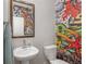 Stylish half bath features a sleek pedestal sink, colorful wall art, and modern fixtures at 243 Commons Ave, Woodstock, GA 30188