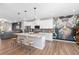 Open kitchen with stainless steel appliances, island with seating, that flows into the living room at 243 Commons Ave, Woodstock, GA 30188