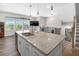 Kitchen island with stainless steel sink, granite counters and faucet with staircase and window view at 243 Commons Ave, Woodstock, GA 30188