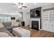 Cozy living room featuring a fireplace, built-in shelving, and view to the open kitchen at 243 Commons Ave, Woodstock, GA 30188