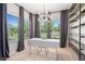Bright home office with a modern light fixture, built-in shelving, and large windows with a view of the outdoors at 243 Commons Ave, Woodstock, GA 30188