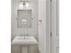 Stylish powder room with a pedestal sink, decorative mirror, and modern fixtures at 3475 Oak Valley Rd # 130, Atlanta, GA 30326