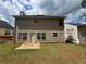 Backyard with a grassy lawn, small patio, and siding exterior elevation at 4884 Browns Mill Ferry Rd, Lithonia, GA 30038