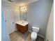 Bathroom features modern vanity, faucet, and commode with updated flooring at 4884 Browns Mill Ferry Rd, Lithonia, GA 30038