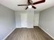 Bedroom featuring modern ceiling fan, updated flooring, and two closets at 4884 Browns Mill Ferry Rd, Lithonia, GA 30038