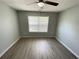 Bright bedroom with updated flooring and a window overlooking a green space at 4884 Browns Mill Ferry Rd, Lithonia, GA 30038
