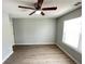 Bedroom boasts a ceiling fan, light gray walls, and updated flooring at 4884 Browns Mill Ferry Rd, Lithonia, GA 30038
