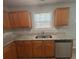 Bright kitchen featuring granite counters, stainless steel dishwasher, and wooden cabinetry at 4884 Browns Mill Ferry Rd, Lithonia, GA 30038