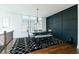 Elegant dining room with hardwood floors, modern lighting, decorative rug, and dark accent wall at 6666 Sterling Dr, Sandy Springs, GA 30328