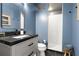 Charming bathroom with blue walls, a marble counter, and a tiled shower at 805 Peachtree Ne St # 220, Atlanta, GA 30308