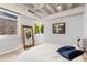 Sunlit bedroom with exposed ceiling, large windows, and stylish full-length mirror at 805 Peachtree Ne St # 220, Atlanta, GA 30308