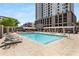 Gorgeous community pool surrounded by lounge chairs and canopies in a sunny outdoor space at 805 Peachtree Ne St # 220, Atlanta, GA 30308