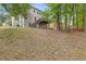 View of backyard featuring trees, grass, and deck with stair access to the home's second level at 861 Southland Pass, Stone Mountain, GA 30087