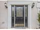 Close up of decorative front door with sidelights and a brass kick plate, flanked by sconces at 861 Southland Pass, Stone Mountain, GA 30087