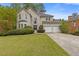 Charming two-story traditional home featuring a manicured lawn, attached two-car garage, and lush, mature landscaping at 861 Southland Pass, Stone Mountain, GA 30087