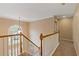 Upstairs hallway with staircase and chandelier, features carpet floors and natural lighting at 861 Southland Pass, Stone Mountain, GA 30087