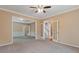 Open-concept living room with carpet, a ceiling fan, and double french doors to other living spaces at 861 Southland Pass, Stone Mountain, GA 30087