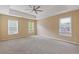 Spacious primary bedroom with ceiling fan, neutral walls, carpet floors, and large windows at 861 Southland Pass, Stone Mountain, GA 30087