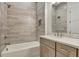 Bathroom featuring stone tile, vanity, and bathtub-shower combination at 140 Rolison Way, Fayetteville, GA 30214