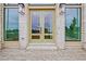 Elegant double doors surrounded by large windows on a brick home with stylish exterior lighting at 140 Rolison Way, Fayetteville, GA 30214
