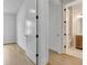 Hallway with blonde hardwood floors leading to a bathroom with a wooden vanity at 140 Rolison Way, Fayetteville, GA 30214