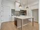 Open kitchen with an island featuring a stainless steel sink, and gray backsplash at 140 Rolison Way, Fayetteville, GA 30214