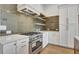 Modern kitchen with stainless steel oven, sleek backsplash, and white cabinets at 140 Rolison Way, Fayetteville, GA 30214