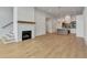 Bright living room with hardwood floors, a modern brick fireplace, and an open view of the kitchen and dining area at 140 Rolison Way, Fayetteville, GA 30214