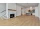 Bright living room with hardwood floors, fireplace, and open access to modern kitchen with stainless appliances at 140 Rolison Way, Fayetteville, GA 30214