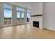 Living room featuring hardwood floors, fireplace and large windows offering natural light and outdoor views at 140 Rolison Way, Fayetteville, GA 30214
