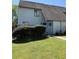 Exterior view of home with green grass, large bushes, and two-car garage at 296 Country Club Dr, Jonesboro, GA 30238