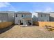 Backyard with a grass, a wooden fence, a covered patio, and neighboring houses under a clear sky at 3020 Westgate Park Dr, Loganville, GA 30052