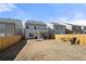 Backyard with a grass, a wooden fence, a covered patio, and neighboring houses under a clear sky at 3020 Westgate Park Dr, Loganville, GA 30052