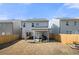 Backyard with a grass, a wooden fence, a covered patio, and neighboring houses under a clear sky at 3020 Westgate Park Dr, Loganville, GA 30052
