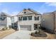 Two-story home boasting white brick, a covered entryway, and a two-car garage with a concrete driveway at 3020 Westgate Park Dr, Loganville, GA 30052