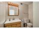 Tiled bathroom featuring a wood vanity, mirror, and a toilet with a clean and functional design at 5000 Bainbridge Sw Ct, Lilburn, GA 30047