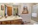 Bathroom with single sink vanity, shower-tub combo, and floral wallpaper at 5000 Bainbridge Sw Ct, Lilburn, GA 30047