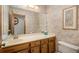 A vintage bathroom featuring a floral wallpaper, single sink vanity, and a large mirror at 5000 Bainbridge Sw Ct, Lilburn, GA 30047