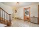 A tiled foyer with a wooden staircase, decorative accents, and natural light at 5000 Bainbridge Sw Ct, Lilburn, GA 30047